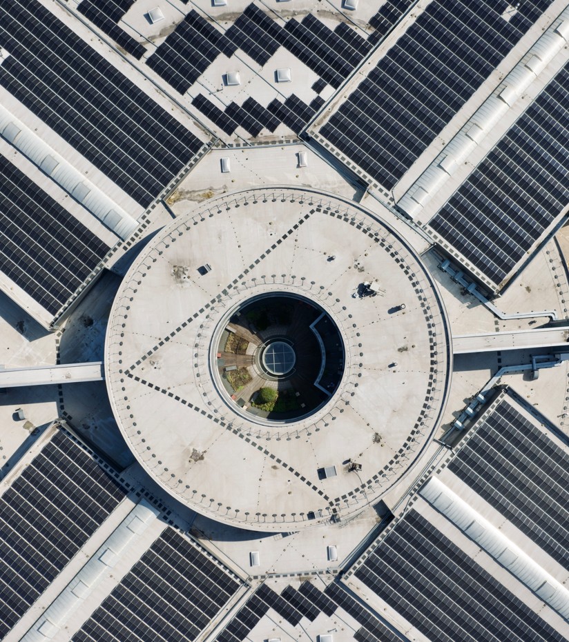 Runder Gebäudekomplex mit Photovoltaikanlage auf den Dächern von oben